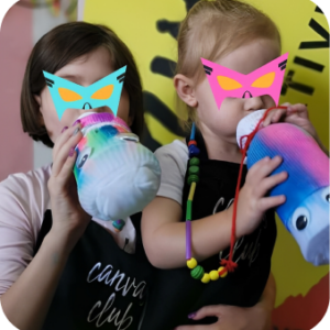 Two children in colorful masks drinking from bottles